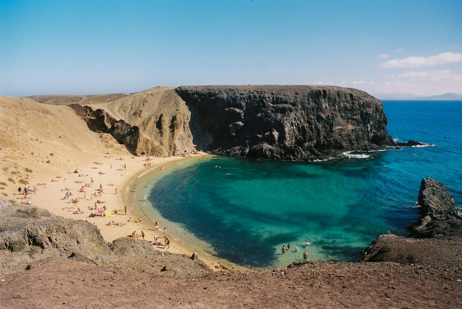Playa de arena clara junto a acantilados en Lanzarote