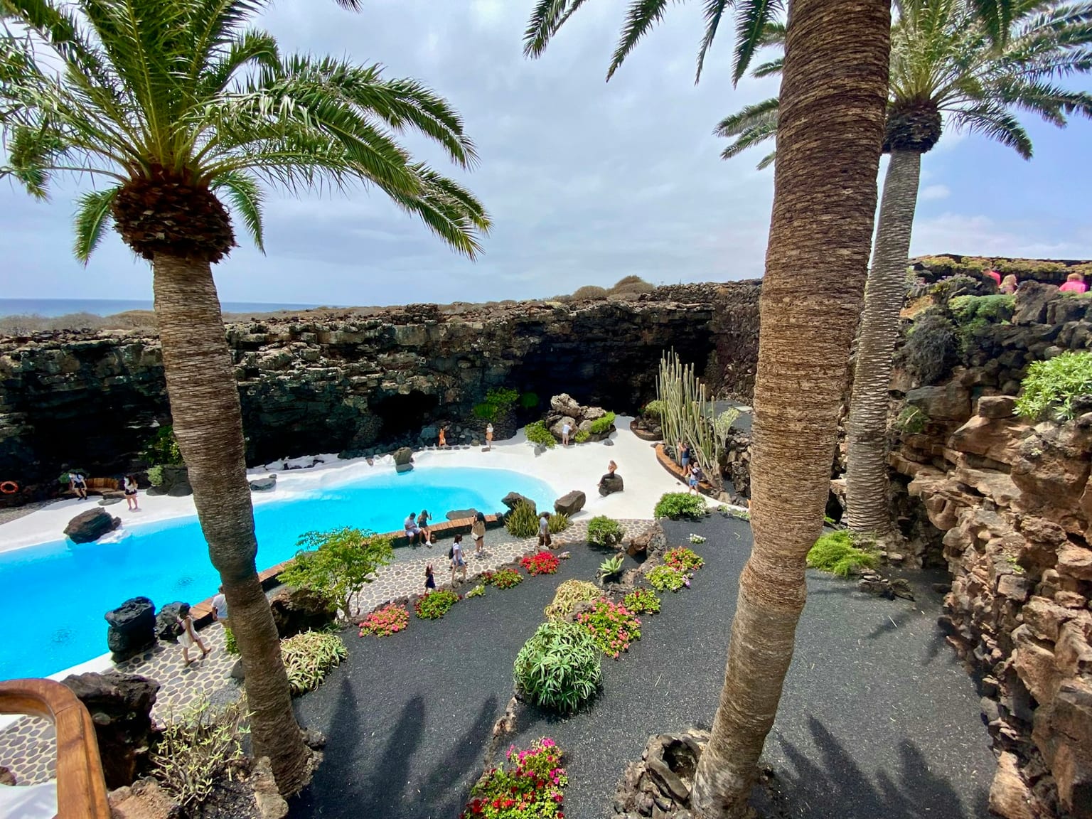 Piscina y palmeras junto a la costa de Lanzarote